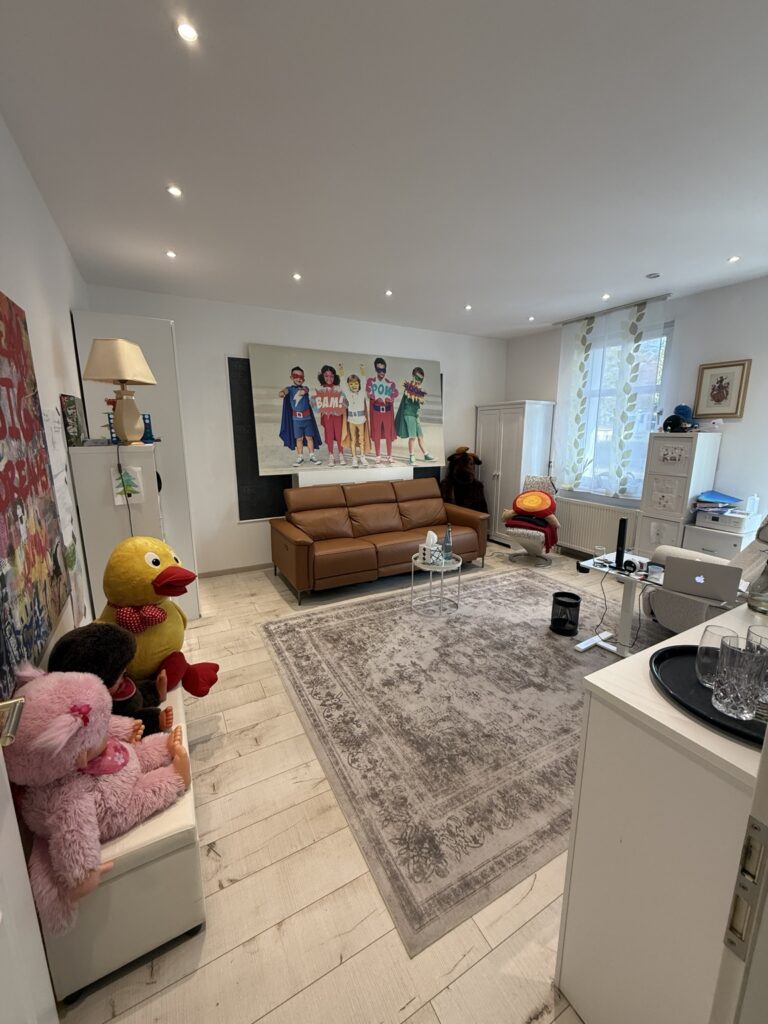 Praxisraum von echt. therapie in Eichwalde mit braunem Sofa, Sesseln und Spielpuppen